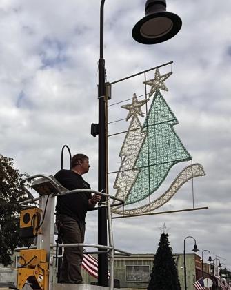 That’s Brian Adcock, owner of Santa Beacon’s holiday lighting business, who is hanging a double tree ornament on the East Main lamp post. That’s Brian Adcock, owner of Santa Beacon’s holiday lighting business, who is hanging a double tree ornament on the East Main lamp post.