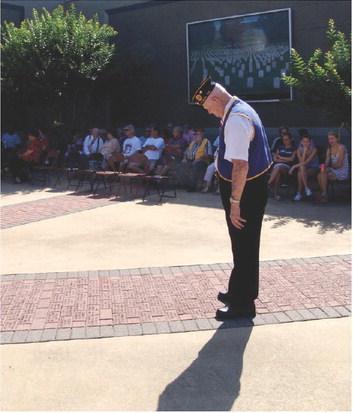 A member of American Legion Post 258 pauses and looks down to see and read names. MEMORIAL DAY