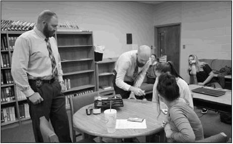 Officers Hagan Allen, left, and Cody Sartor visited Queen City High School to demonstrate different fingerprinting techniques. Queen City students learn fingerprinting techniques