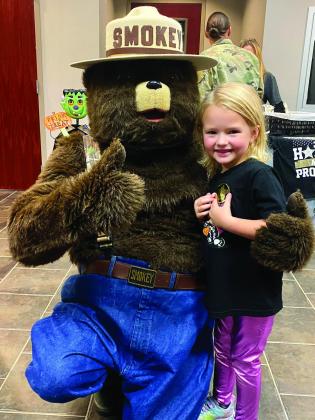 Roslyn Burbridge, 4, was excited to give Smokey a hug while baby sister Reba, 2, clung to their mother Brittany Burbridge just out of frame. The girls come from a line of Forestry service workers—-grandfather Johnny Duncan and their father James Burbrid Roslyn Burbridge