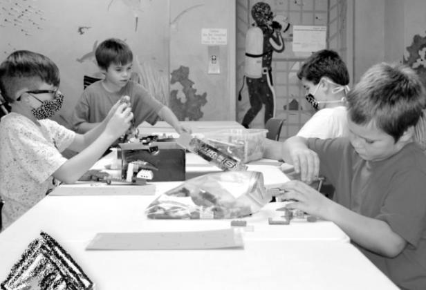 Photo by Kate Stow Members of the Lego Club, Dakota, Stephen, Hayden and Isaac, are hard at work building their first mission. Library offers unique after school clubs