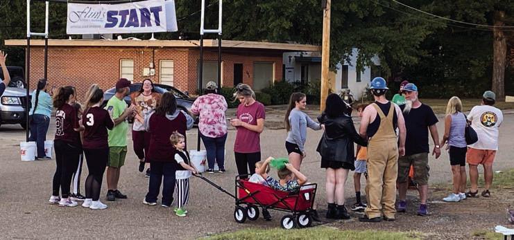 Families gather at the finish line waiting on their Monster Milers Hiram haunted by glowing goblins, ghouls