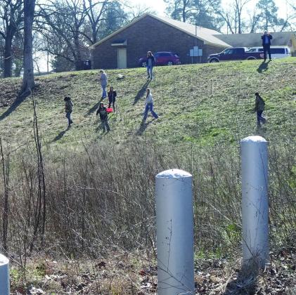 This area on the north side of the senior citizens center in Linden shows the site being proposed for a brick-making memorial.The young individuals on the bluff are spreading wild flower seeds to help beautify the grounds and prevent soil erosion. A creek Linden City Park