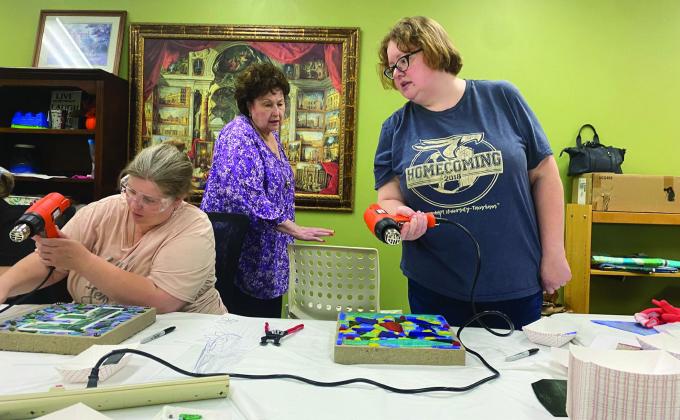Kendra gives the class instructions on how to properly dry their glue for the best outcome. Mosaic crafting at Atlanta Public Library