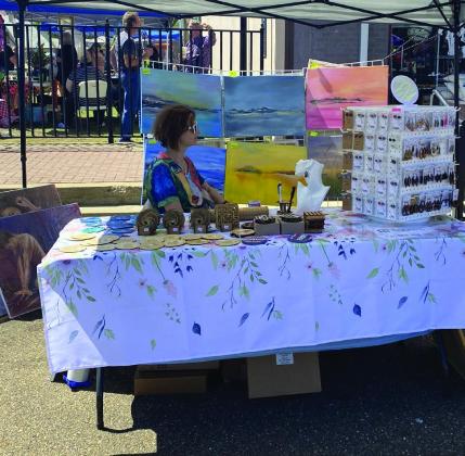 Nadia strikes a pose unaware as she enjoys the sunshine at her booth with an eclectic variety of oil and acrylic art for sale. Spring Maker’s Market makes its mark