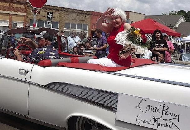 Laura Penny has just been helping out with the Wildflower Trails flower show. She’s made it to her parade as Grand Marshal. She’s brought her flowers along, too, naturally. Parade Leaders