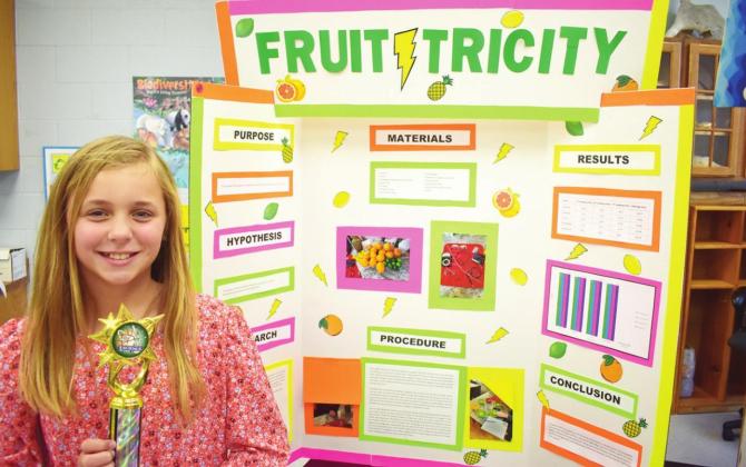 Maggie Rudel won first place at the J.K. Hileman Elementary Science Fair for her “Fruitricity” project. BELOW: Jordan Young placed second for her entry. Photos by Phyllis Warren J.K. Hileman Science Fair