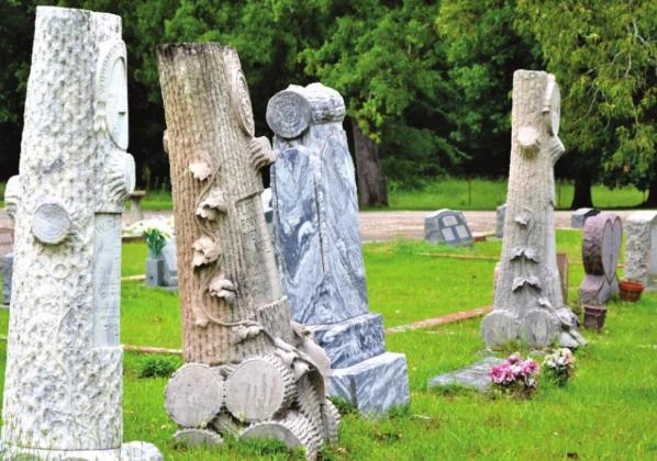 A row of ornate Woodmen of the World monuments. Laws Chapel Methodist Church and Cemetery