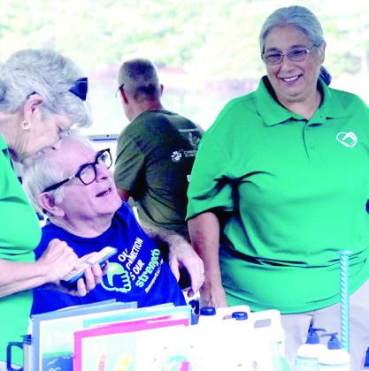 Smiles and happiness are on the faces Gary Daniel, seated, his wife Rori at right and retired attorney Leslie Fox. They are supporting the second annual Trail Grinder run to bring attention to Superficial Siderosis, of which Gary suffers. Area runs for Siderosis