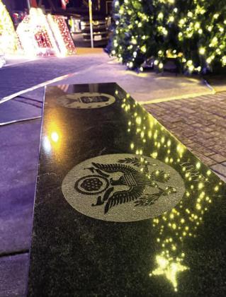A bonus of holiday night lights at the veterans’ plaza is that the military monuments and benches reflect the lights.A moment’s pause is engendered for each black granite insignia. A bonus of holiday night lights at the veterans’ plaza is that the military monuments and benches reflect the lights.A moment’s pause is engendered for each black granite insignia.