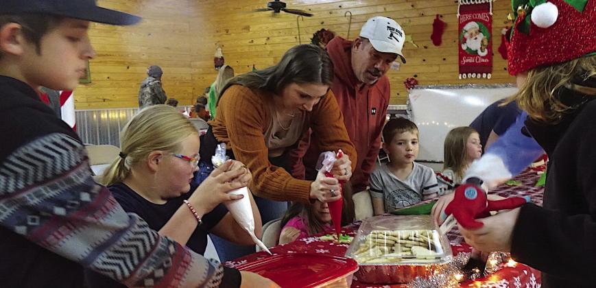 Errysa Ramage helps squeezes decoration on cookies while Bloomburg city councilman Casey Kelley looks on. Santa visits Bloomburg
