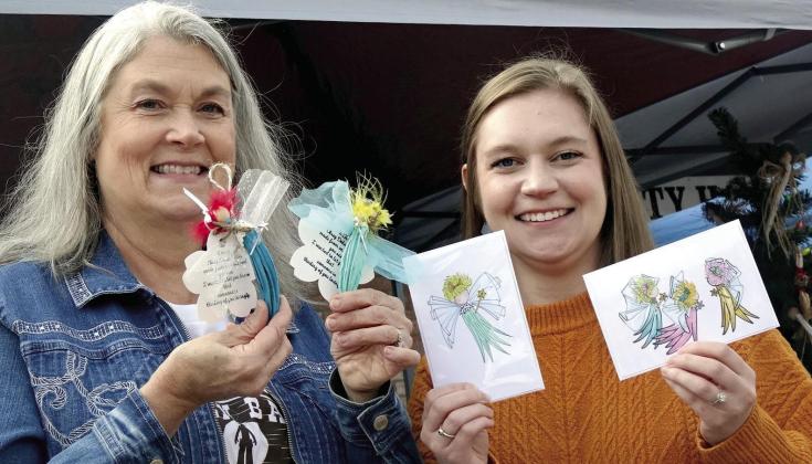 Lisa Smith, left, makes ornamental decorations of okra.That’s an okra fairy she’s holding right now. Daughter Caroline Heflin is glad mother is so creative. Daughter makes artistic gift cards of her mother’s okra. Okra: Dinner AND art!