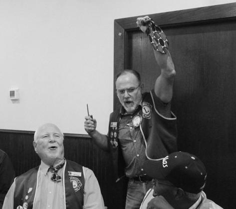 Tail Twister Stuart holds up the cut tie to remind the rest of the room the penalty for breaking the rules. Photos by Casey Williams