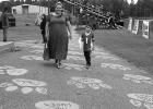 All around Queen City High are student messages and paintings. At the football stadium, Tabitha Proctor and her son Cohen are walking on the Paw Prints Road, a project which raises money for seniors.