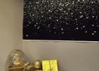 A corner display is brightened with gold packages and a striking work of art on the wall.