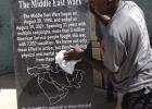 The West Memorials monument employee is showing his care by polishing the granite slab with its wording, ‘The Middle East Wars.” This monument explains the display’s purpose.